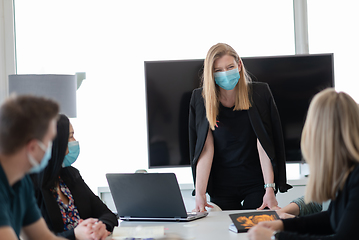 Image showing real business people on meeting wearing protective mask