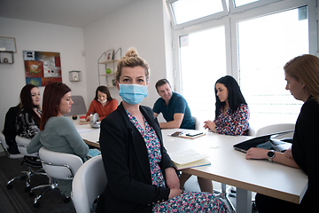 Image showing real business people on meeting wearing protective mask