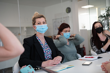 Image showing real business people on meeting wearing protective mask