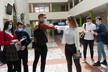 Image showing students greeting new normal coronavirus handshake and elbow bumping