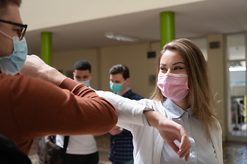 Image showing students greeting new normal coronavirus handshake and elbow bumping