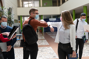 Image showing students greeting new normal coronavirus handshake and elbow bumping
