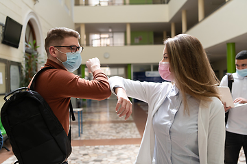 Image showing students greeting new normal coronavirus handshake and elbow bumping