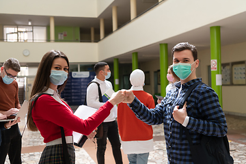 Image showing students greeting new normal coronavirus handshake and elbow bumping