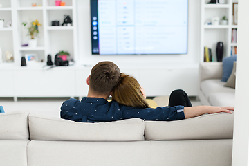 Image showing young couple watching tv at home in bright living room