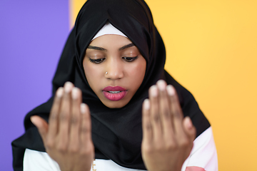 Image showing african muslim woman wearing hijab and traditional muslim clothes posing in front of green background