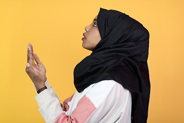 Image showing african muslim woman wearing hijab and traditional muslim clothes posing in front of green background