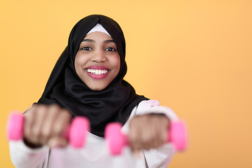 Image showing afro muslim woman promotes a healthy life, holding dumbbells in her hands