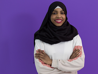 Image showing portrait of african muslim woman wearing hijab and traditional muslim clothes posing in front of purple background