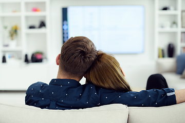 Image showing young couple watching tv at home in bright living room