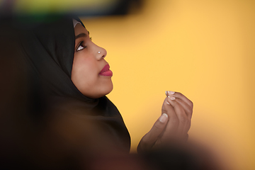 Image showing african muslim woman wearing hijab and traditional muslim clothes posing in front of green background