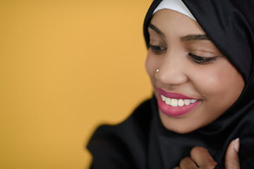 Image showing african muslim woman with a beautiful smile takes a selfie with a cell phone