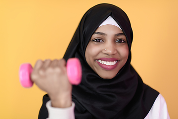 Image showing afro muslim woman promotes a healthy life, holding dumbbells in her hands