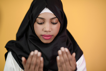 Image showing african muslim woman wearing hijab and traditional muslim clothes posing in front of green background