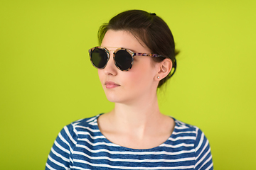 Image showing woman in sunglasses posing in front of a green background