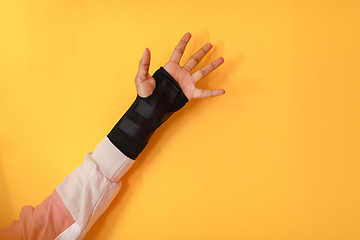 Image showing hand injury. a female injured hand on a yellow background