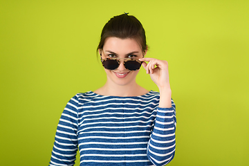 Image showing woman in sunglasses posing in front of a green background