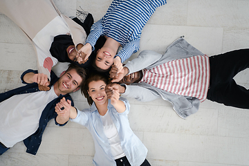 Image showing top view of a diverse group of people lying on the floor and symbolizing togetherness