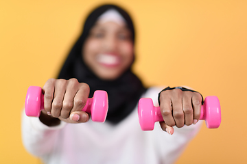 Image showing afro muslim woman promotes a healthy life, holding dumbbells in her hands