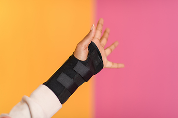 Image showing hand injury. a female injured hand on a yellow background