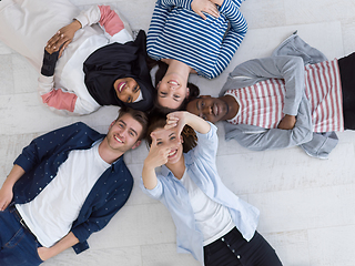 Image showing top view of a diverse group of people lying on the floor and symbolizing togetherness