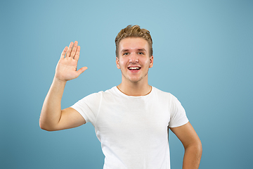 Image showing Caucasian young man\'s half-length portrait on blue background