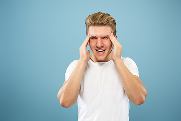 Image showing Caucasian young man\'s half-length portrait on blue background