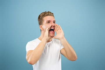 Image showing Caucasian young man\'s half-length portrait on blue background