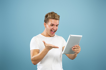 Image showing Caucasian young man\'s half-length portrait on blue background