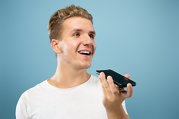 Image showing Caucasian young man\'s half-length portrait on blue background