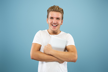 Image showing Caucasian young man\'s half-length portrait on blue background