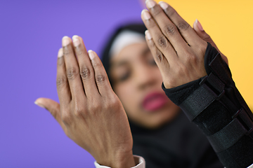 Image showing african muslim woman wearing hijab and traditional muslim clothes posing in front of green background