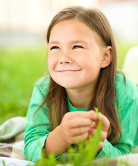 Image showing Portrait of a little girl laying on green grass