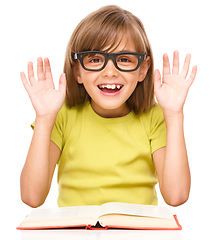 Image showing Little girl is reading a book