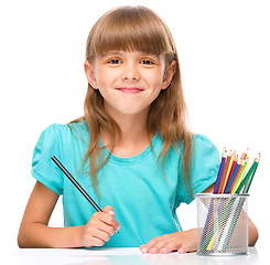 Image showing Little girl is drawing using pencils