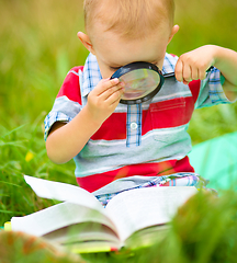 Image showing Little boy is reading book