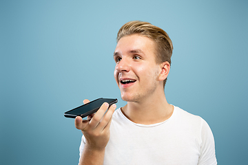 Image showing Caucasian young man\'s half-length portrait on blue background