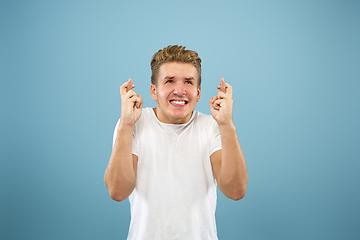 Image showing Caucasian young man\'s half-length portrait on blue background