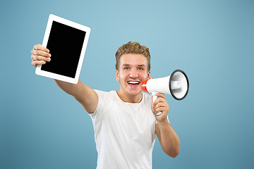 Image showing Caucasian young man\'s half-length portrait on blue background