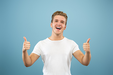 Image showing Caucasian young man\'s half-length portrait on blue background