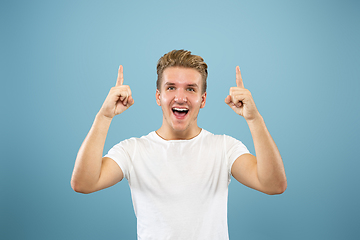 Image showing Caucasian young man\'s half-length portrait on blue background