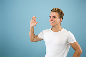 Image showing Caucasian young man\'s half-length portrait on blue background