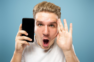 Image showing Caucasian young man\'s half-length portrait on blue background