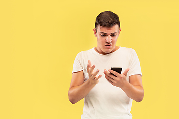 Image showing Caucasian young man\'s half-length portrait on yellow background