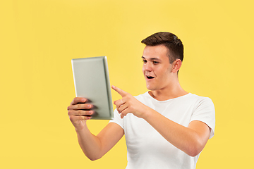 Image showing Caucasian young man\'s half-length portrait on yellow background