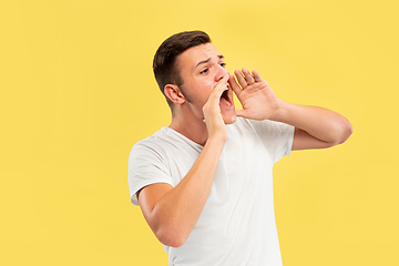 Image showing Caucasian young man\'s half-length portrait on yellow background