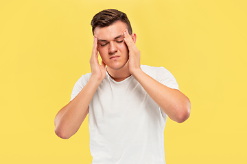 Image showing Caucasian young man\'s half-length portrait on yellow background