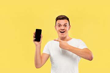 Image showing Caucasian young man\'s half-length portrait on yellow background