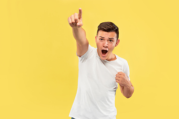 Image showing Caucasian young man\'s half-length portrait on yellow background