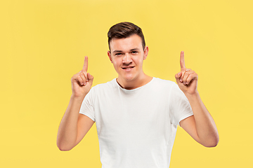 Image showing Caucasian young man\'s half-length portrait on yellow background